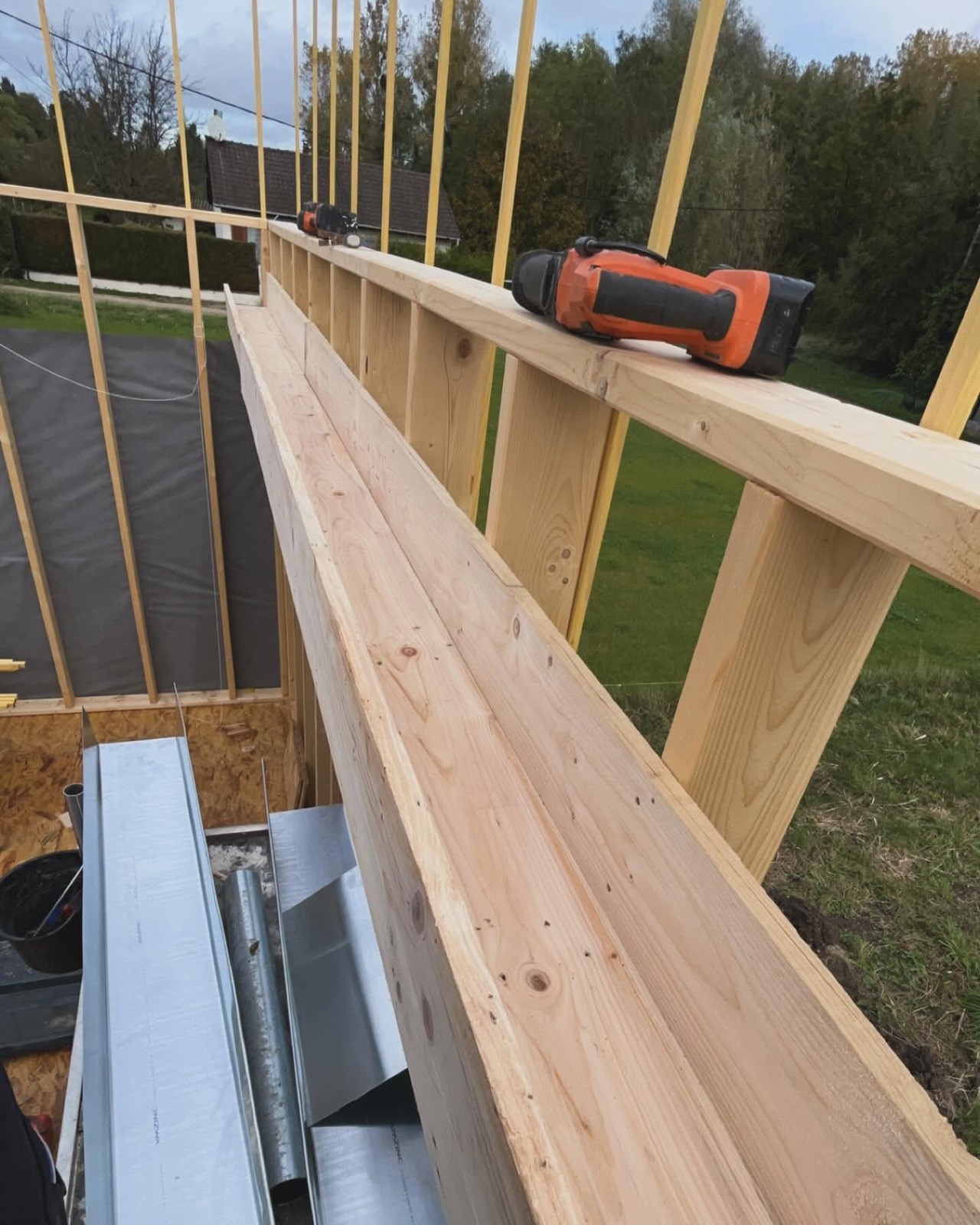 Ossature bois en construction, pièces de zinc façonnées au pied de la paroi