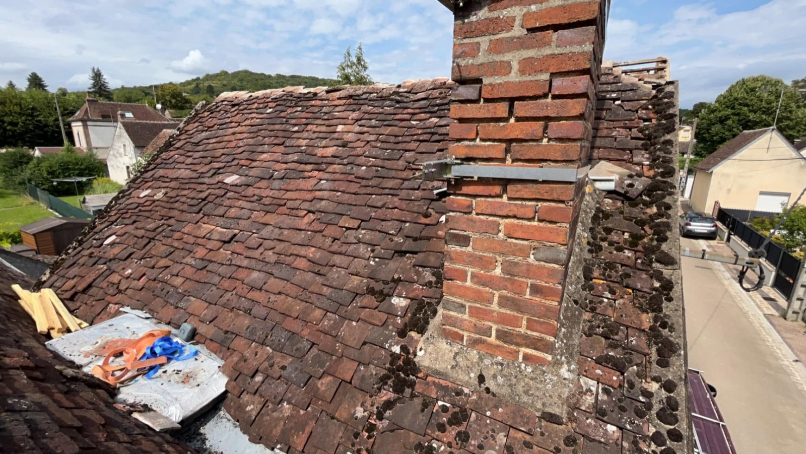 Souche de cheminée en brique au milieu des petites tuiles, Villecien